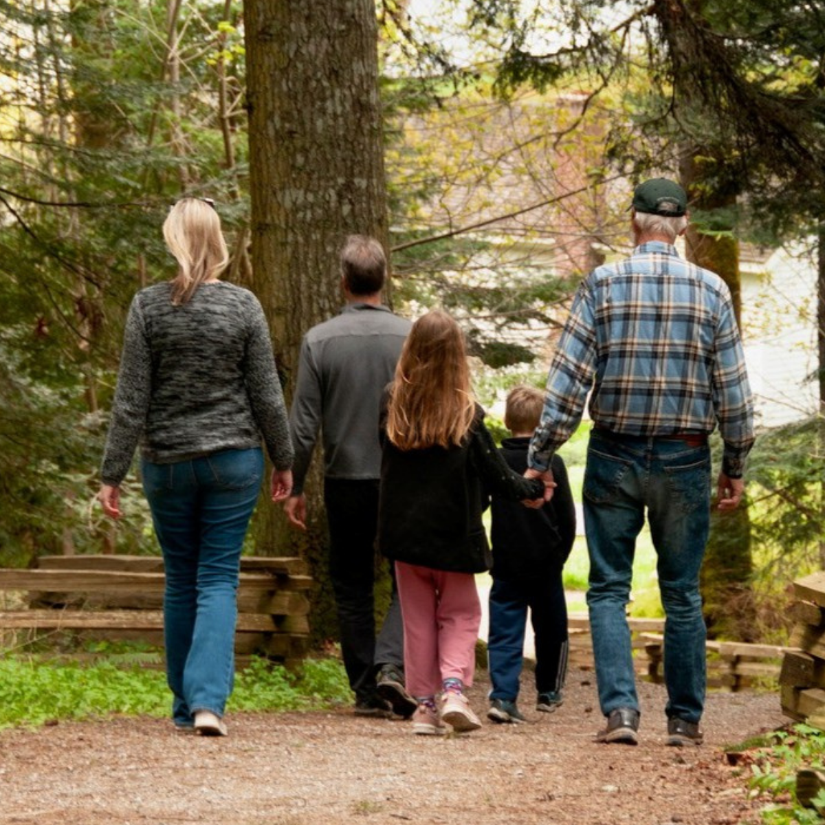 Untitled design (23) family walking down a trail in the forrest together