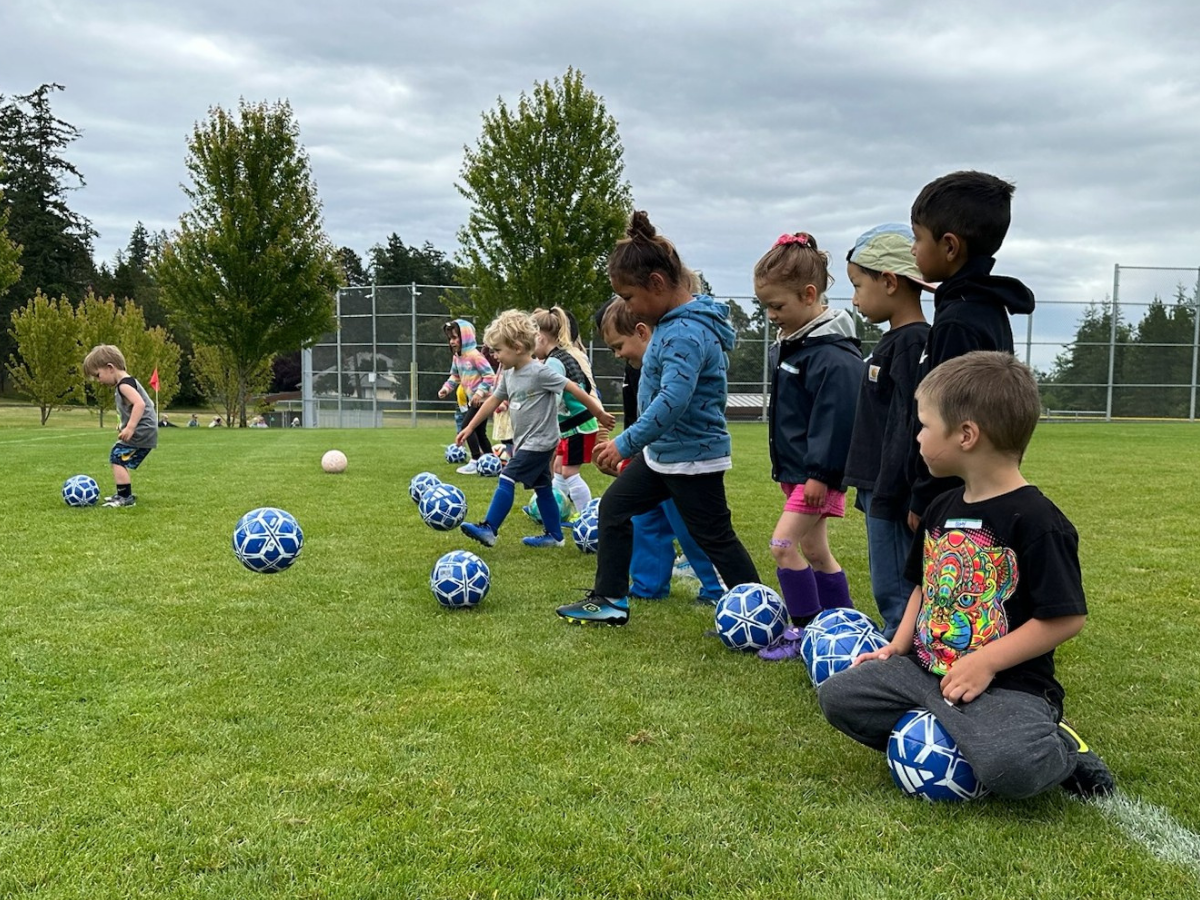 preschoolers in a row with soccer balls
